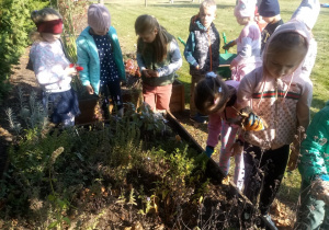 dzieci porządkują grupowy ogródek